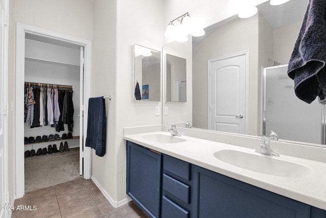 bathroom featuring tile patterned flooring, vanity, and a shower with shower door