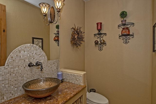 bathroom with vanity, backsplash, and toilet