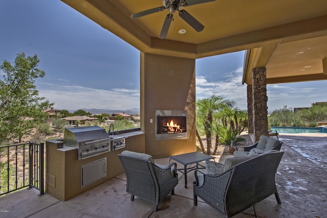 view of patio / terrace featuring area for grilling, ceiling fan, and an outdoor fireplace