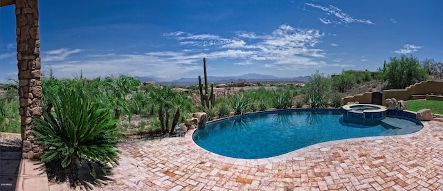 view of swimming pool featuring a mountain view, an in ground hot tub, and a patio