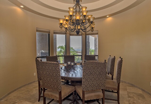 dining space with a notable chandelier and a tray ceiling