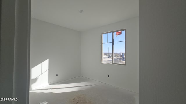 unfurnished room with concrete flooring