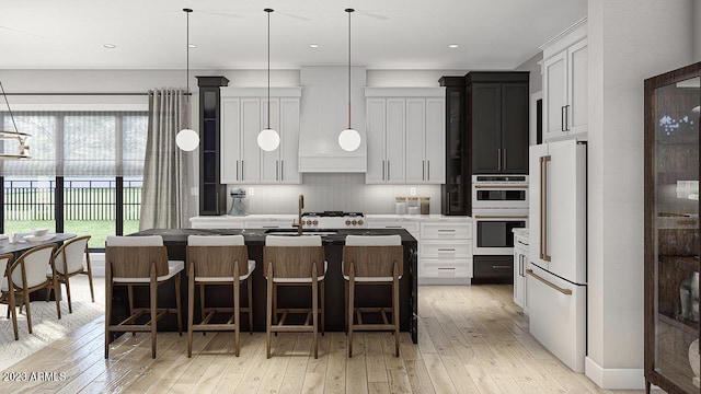 kitchen featuring high end white fridge, sink, light wood-type flooring, an island with sink, and stainless steel double oven