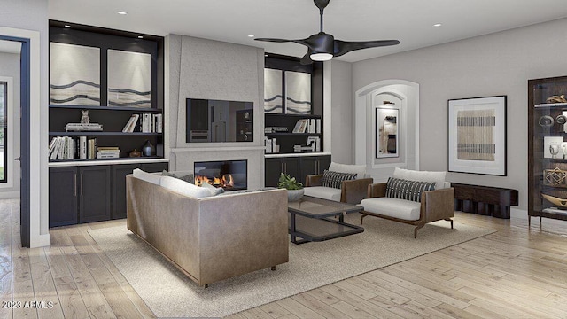 living room with light hardwood / wood-style flooring, built in features, and ceiling fan