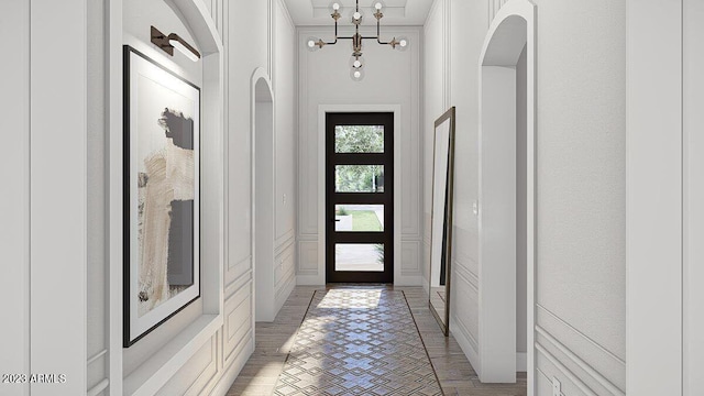 doorway featuring ornamental molding and a notable chandelier