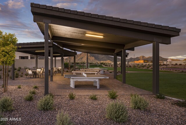 view of home's community featuring a lawn, a mountain view, and a patio