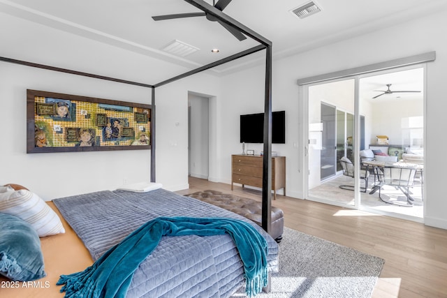 bedroom with access to exterior, visible vents, ceiling fan, and wood finished floors