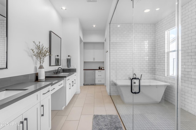 bathroom featuring vanity, a soaking tub, a stall shower, tile patterned floors, and tile walls