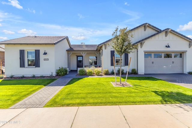 single story home with a garage, a front lawn, driveway, and stucco siding