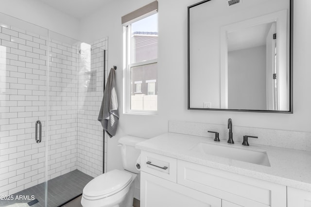 full bathroom with vanity, a shower stall, toilet, and visible vents