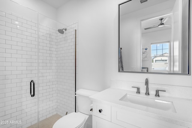 bathroom with visible vents, toilet, a ceiling fan, a shower stall, and vanity