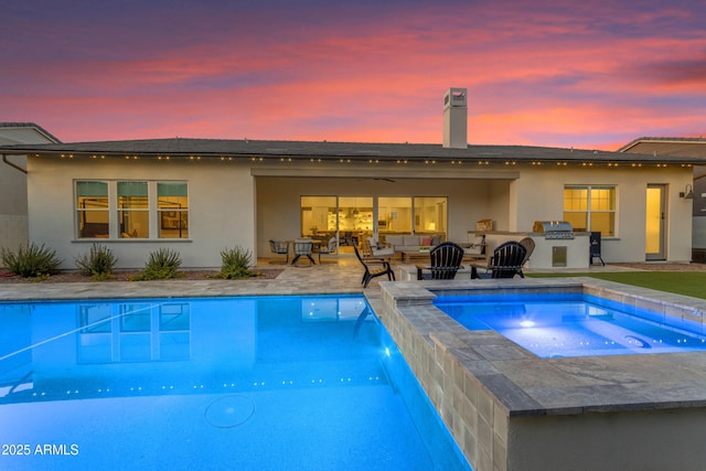 back of house featuring stucco siding, area for grilling, a ceiling fan, a patio, and an outdoor pool