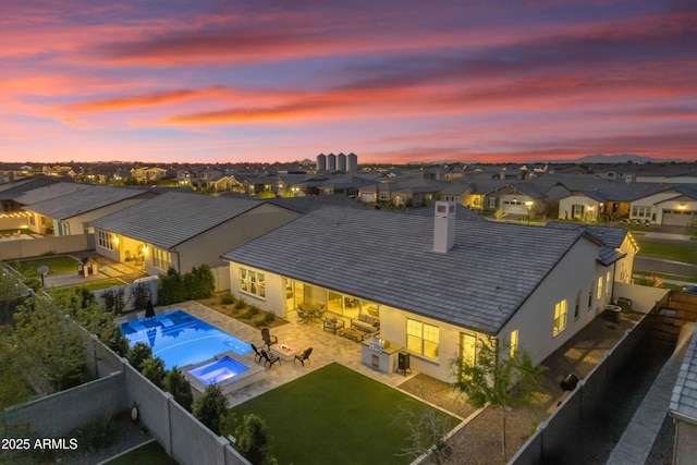 exterior space with a residential view, stucco siding, a chimney, a yard, and a fenced backyard