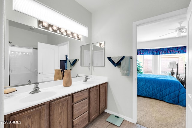 ensuite bathroom with a sink, connected bathroom, ceiling fan, and double vanity