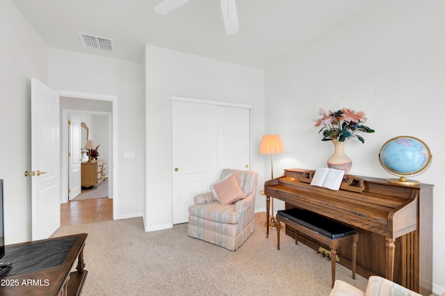 sitting room with visible vents, baseboards, a ceiling fan, and carpet flooring