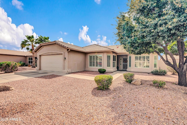 ranch-style home with concrete driveway, an attached garage, a tile roof, and stucco siding