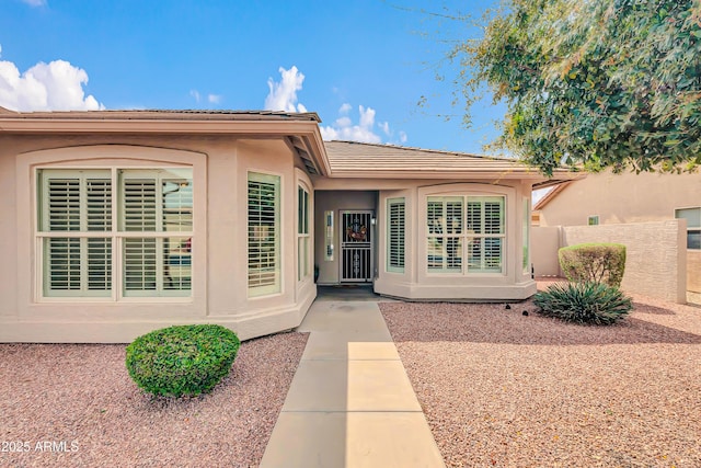 entrance to property featuring stucco siding