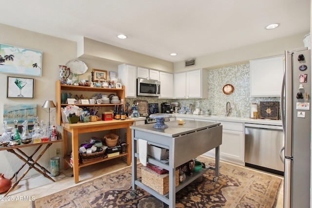 kitchen with stainless steel appliances, light countertops, visible vents, and white cabinetry