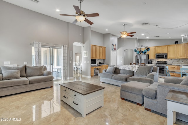 43271 W Little Dr, Maricopa, AZ 85138 - living room featuring a ceiling fan, arched walkways, a towering ceiling, visible vents, and recessed lighting