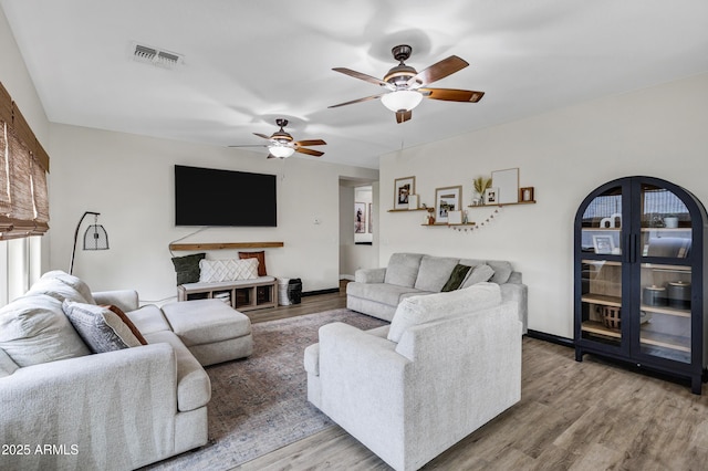 living room with wood-type flooring and ceiling fan