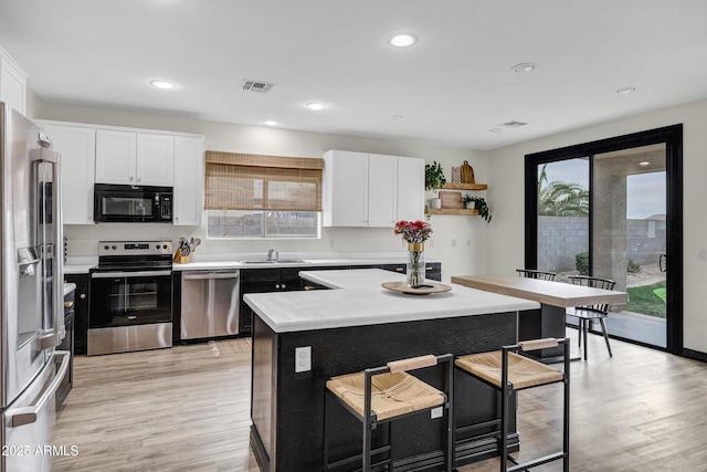 kitchen with white cabinetry, stainless steel appliances, and a center island