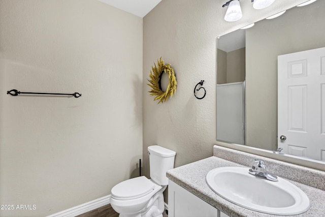 bathroom with hardwood / wood-style flooring, vanity, and toilet