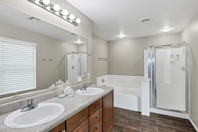 bathroom featuring shower with separate bathtub and vanity