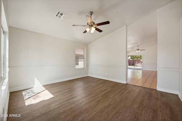 spare room with ceiling fan, dark wood-type flooring, and vaulted ceiling