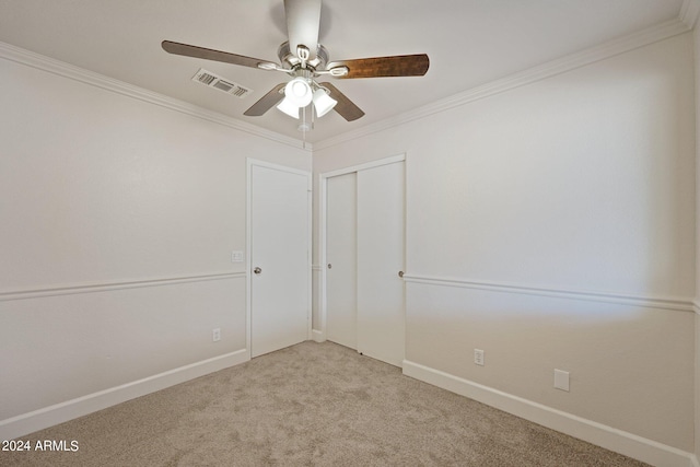 carpeted spare room featuring ceiling fan and ornamental molding