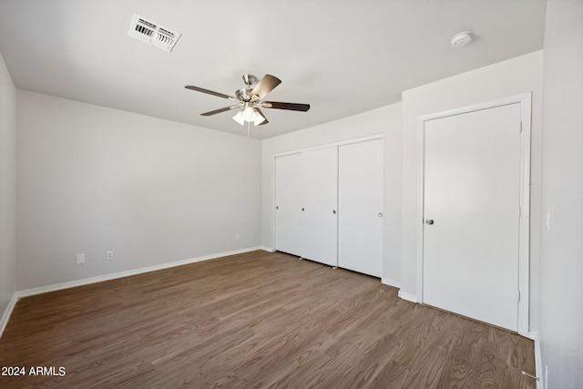 unfurnished bedroom featuring wood-type flooring, ceiling fan, and a closet