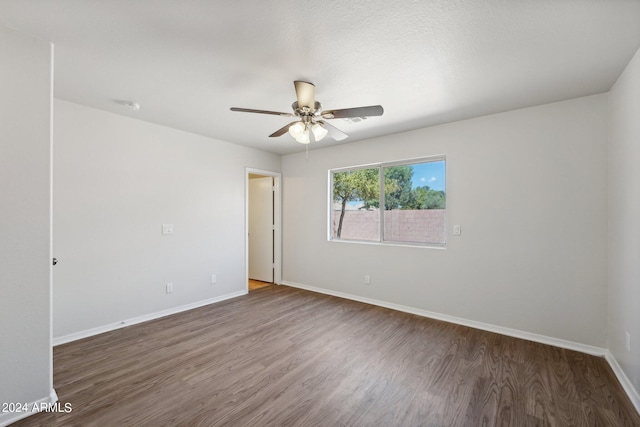 empty room featuring ceiling fan and dark wood-type flooring