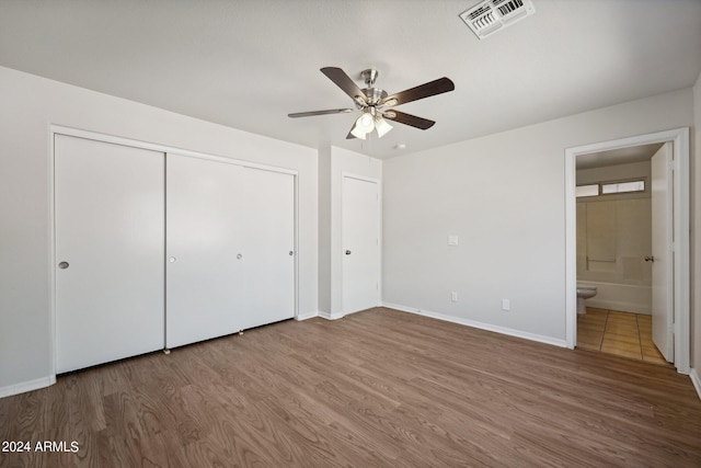 unfurnished bedroom with ceiling fan, hardwood / wood-style flooring, and ensuite bathroom