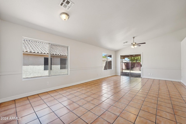 tiled spare room with vaulted ceiling and ceiling fan