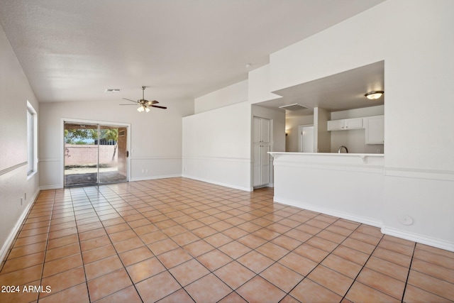 tiled spare room featuring vaulted ceiling and ceiling fan