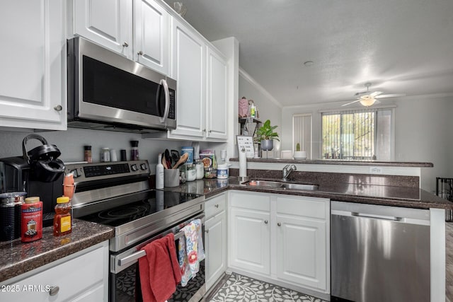 kitchen featuring white cabinetry, sink, kitchen peninsula, and appliances with stainless steel finishes