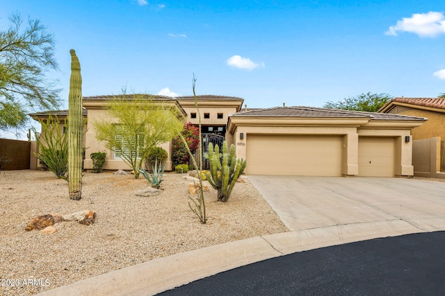 view of front of property featuring driveway, a gate, stucco siding, fence, and an attached garage