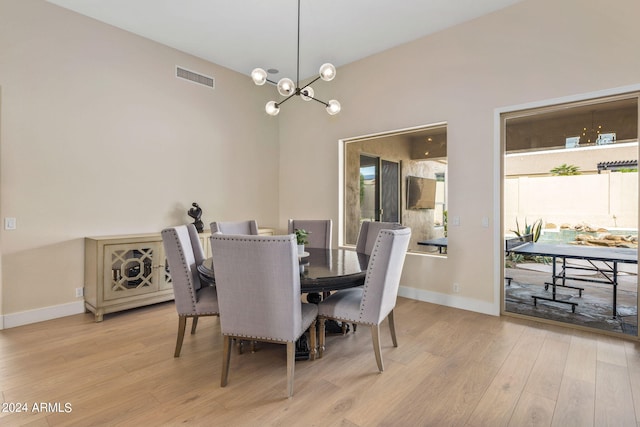 dining area with an inviting chandelier, baseboards, light wood-style floors, and visible vents