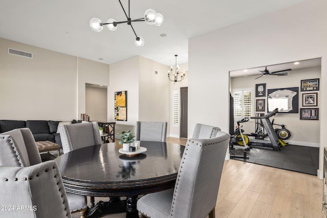 dining room featuring light hardwood / wood-style floors and ceiling fan with notable chandelier