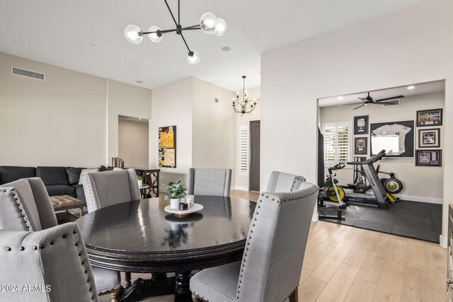 dining room featuring baseboards, a notable chandelier, visible vents, and light wood-style floors