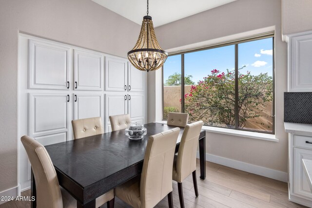 dining room featuring baseboards, a notable chandelier, and light wood-style floors