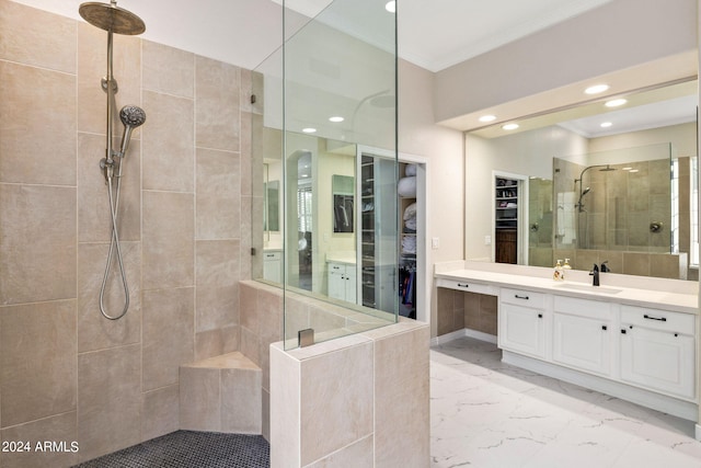 full bathroom featuring vanity, a spacious closet, ornamental molding, marble finish floor, and tiled shower