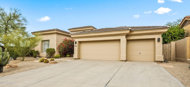 view of front of property featuring fence, driveway, stucco siding, and an attached garage