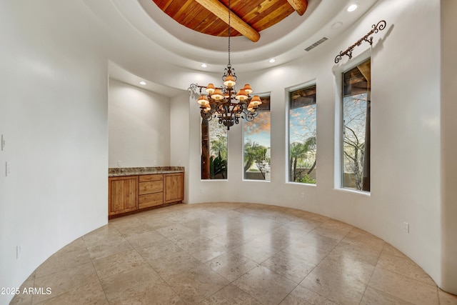 spare room featuring wooden ceiling, a chandelier, and a tray ceiling