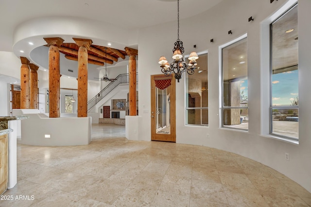 interior space featuring a chandelier, a healthy amount of sunlight, and ornate columns