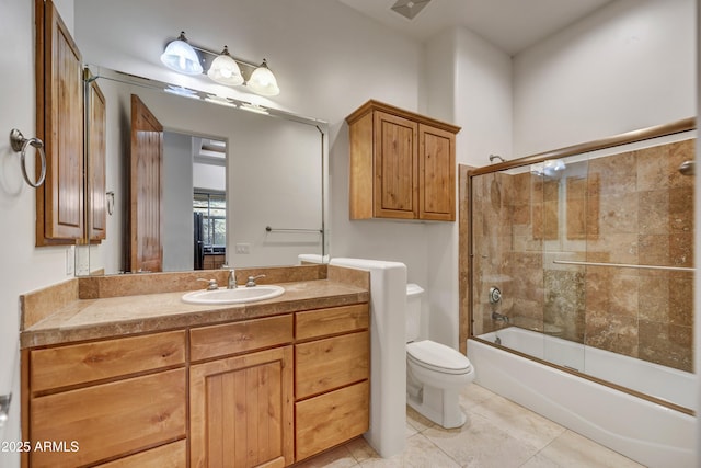 full bathroom with toilet, vanity, bath / shower combo with glass door, and tile patterned flooring