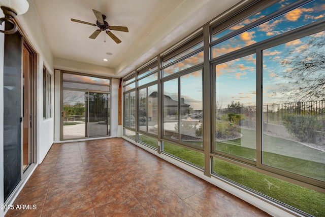 unfurnished sunroom with ceiling fan