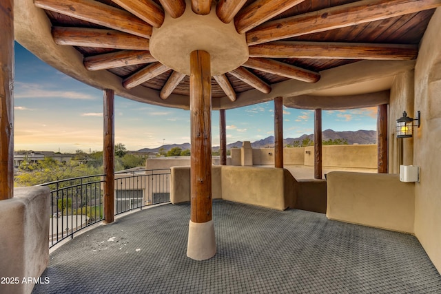 patio terrace at dusk with a balcony and a mountain view