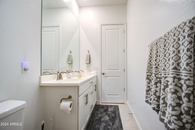 bathroom with vanity, toilet, and tile patterned floors