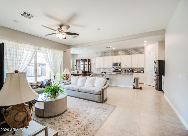 living room with ceiling fan and light tile patterned floors