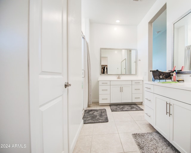 bathroom featuring a shower with door, vanity, and tile patterned flooring